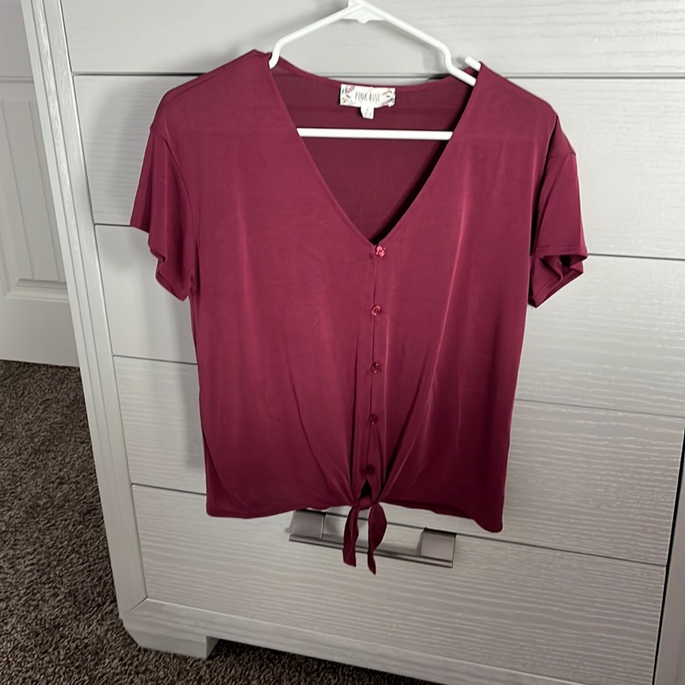 Woman’s deep magenta button up blouse